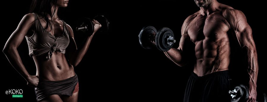 atletyczna para z hantlami na czarnym tle - fototapeta do siłowni, klubu fitness