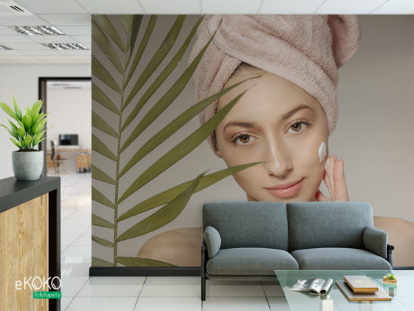 kobieta z ręcznikiem na głowie nakłada krem - fototapeta do salonu kosmetycznego