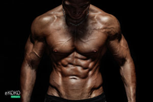 muskularny męski tors na czarnym tle - fototapeta do siłowni, klubu fitness