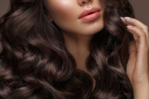 piękna brunetka o długich kręconych włosach - fototapeta do salonu fryzjerskiego, kosmetycznego