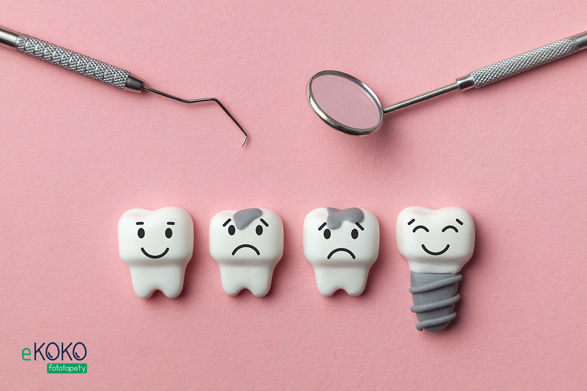 narzędzia dentystyczne i modele zębów w różnym stanie na różowym tle - fototapeta do gabinetu stomatologicznego